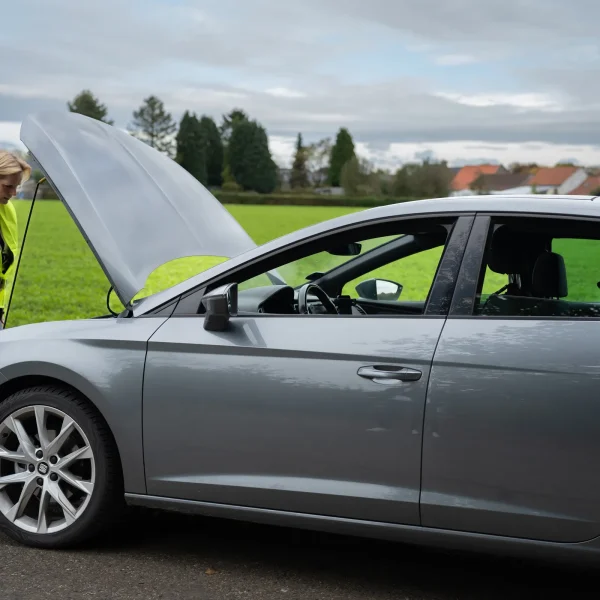 Vrouw stapt uit om motorruimte te controleren