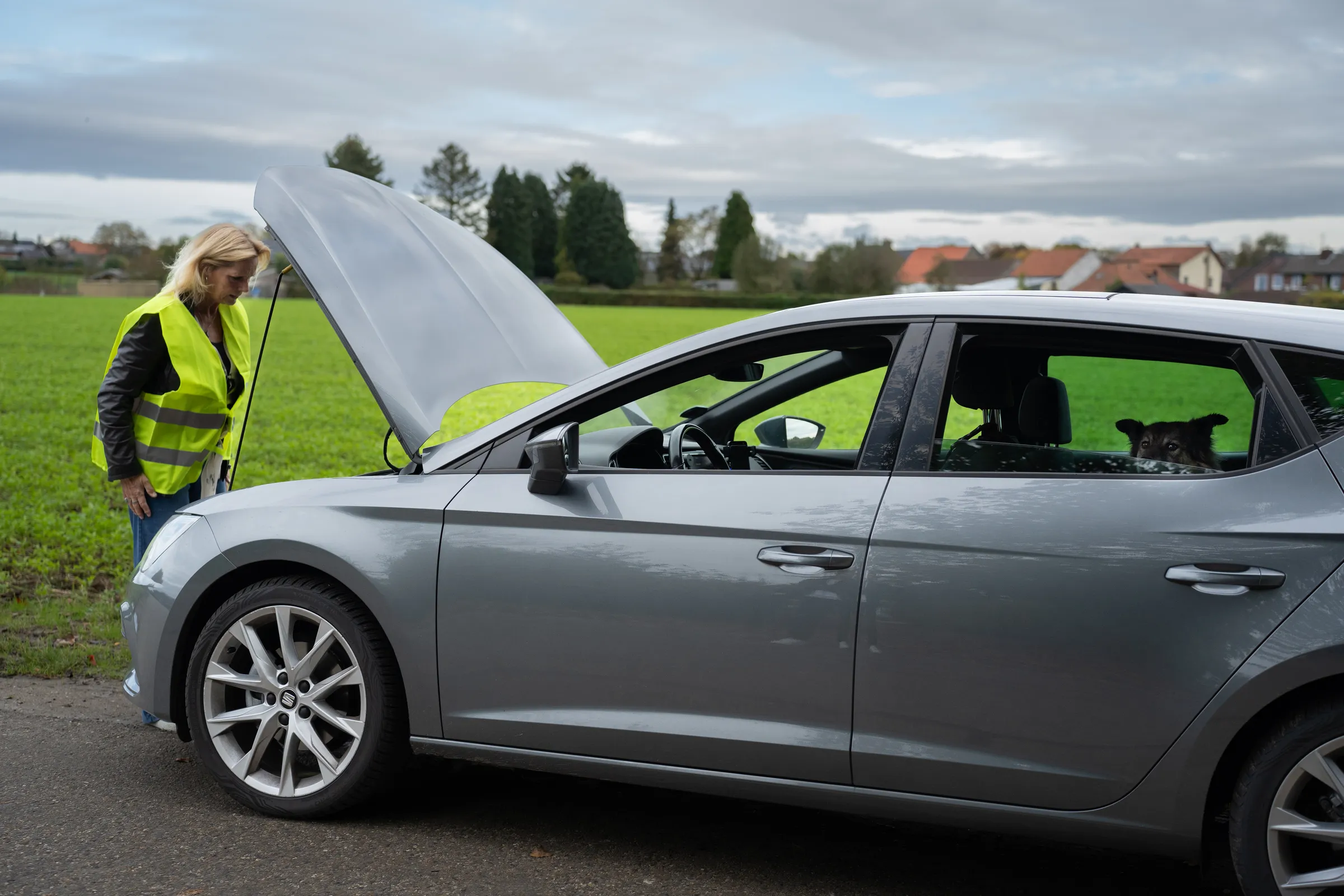 Vrouw stapt uit om motorruimte te controleren
